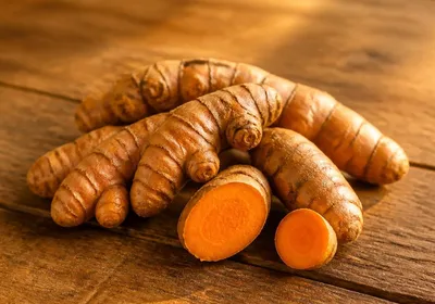 Racines fraîches de curcuma sur une table rustique